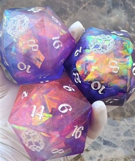 Three Purple And Blue Dice With White Numbers On Them In The Palm Of A Person S Hand