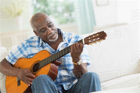 Black Man Playing Guitar On Sofa Stock Photo Dissolve