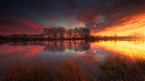 Lake Between Green Grass And River During Sunset Under Red Cloudy Sky