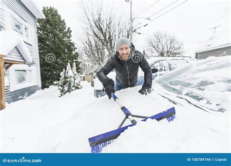 Man Brushing The Snow Off The Windshield Of His Car Stock Photo Image