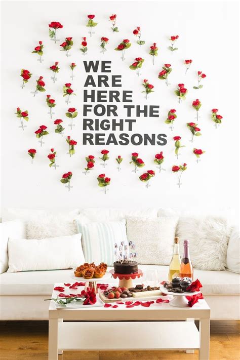 A Living Room Filled With White Furniture And Red Roses On The Wall Above It Is A Coffee Table