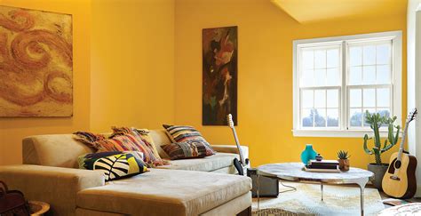 This living room features a large stone fireplace with a large widescreen tv on top. Yellow Living Room Ideas and Inspirational Paint Colors | Behr