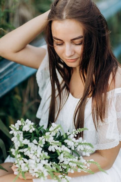 Premium Photo Beautiful Young Woman With A Bouquet Of Wildflowers With Makeup Outdoors
