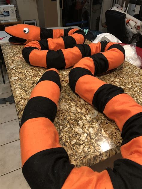 Two Orange And Black Snake Shaped Objects Sitting On Top Of A Counter