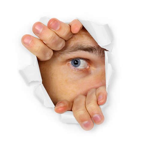 Young Man Peeking Through A Hole In The Paper Stock Photos Pictures