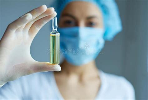 Doctor Nurse Or Scientist Hand In Gloves Holding Ampule With Liquid