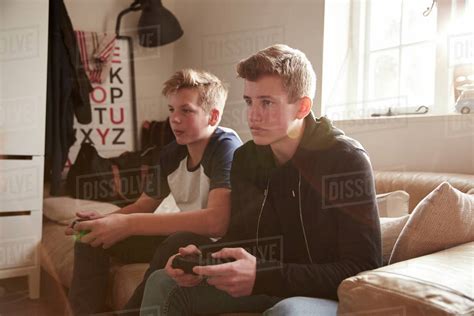 Two Teenage Boys Playing Video Game In Bedroom Stock Photo Dissolve