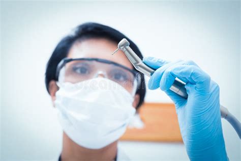 Female Dentist In Surgical Mask Holding Dental Drill Stock Image