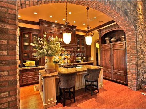 Muted tuscan decorating colors ~ anghiri, tuscany, italy. Tuscan kitchen with pendant lights and stone arch. The Tuscan style lighting is great in thi ...