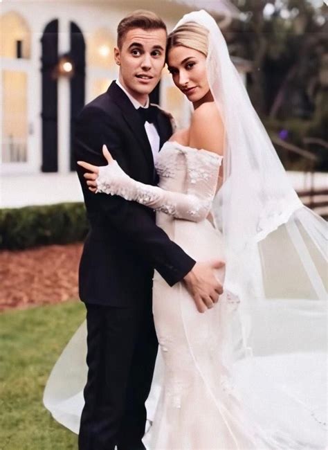 A Bride And Groom Posing For A Photo In Front Of A White House At Night