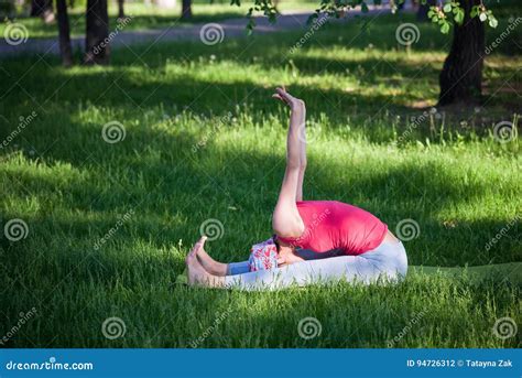 Flexible Young Woman Practicing Yoga And Gymnastics In The Park Yoga
