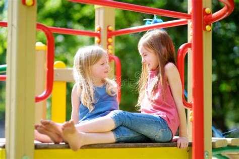 Two Cute Little Girls Having Fun On A Playground Outdoors Stock Image