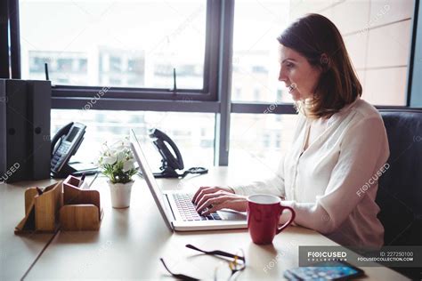 Businesswoman Working On Laptop In Office — Formal Wear Wireless