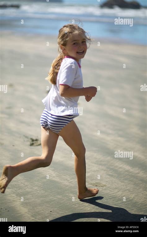 Mädchen läuft am Strand des kleinen Okains Bay bei Ebbe Okains Bay
