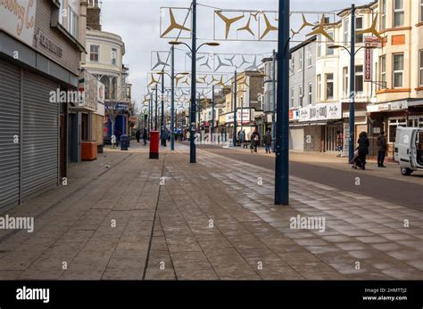 view of regent road great yarmouth in winter with small number of shops open and pedestrians