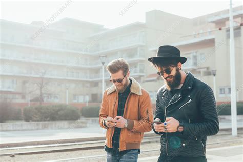 Two Male Hipsters Looking At Smartphones Stock Image F0209280