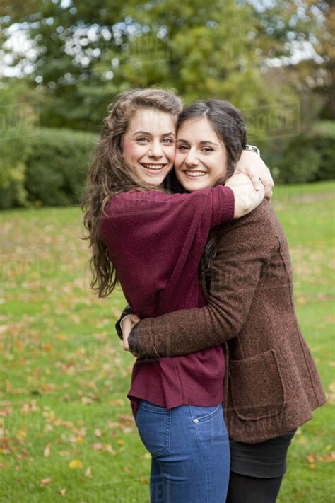 Smiling Girls Hugging In Park Stock Photo Dissolve