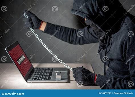 Male Hacker Locking Computer By Using Chain And Padlock Stock Photo
