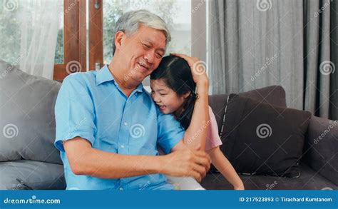 Asian Grandfather Talking With Granddaughter At Home Senior Chinese