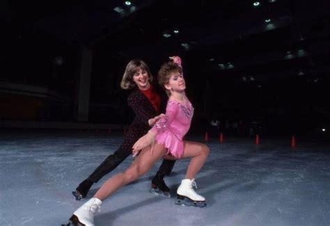 Two People Are Skating On An Ice Rink At Night One Is Holding The Other S Leg