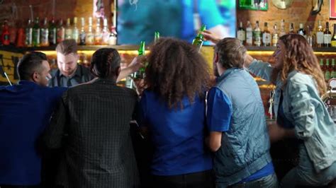 Football Fans Of Different Races Drink Beer And Enjoy Scoring A Goal During A Football Match