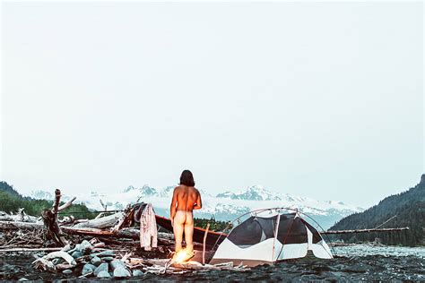 Naked Man Warms His Backside By A Campfire At A Makeshift Campsite In The Alaskan Wilderness