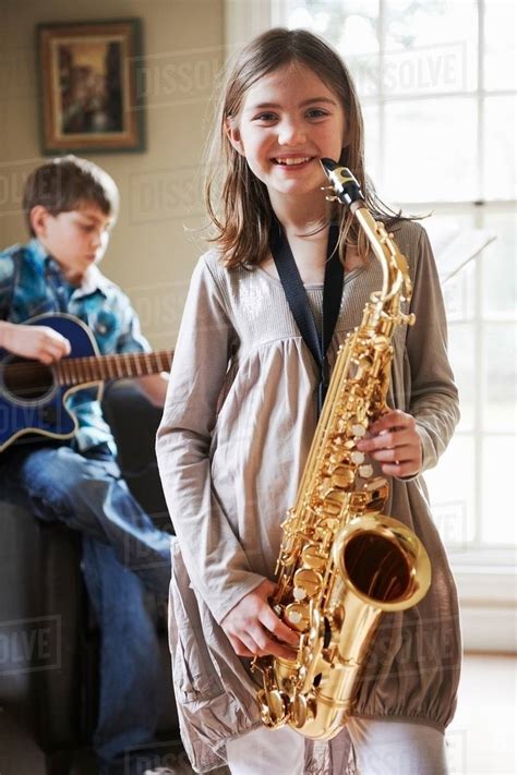 Smiling girl playing saxophone - Stock Photo - Dissolve