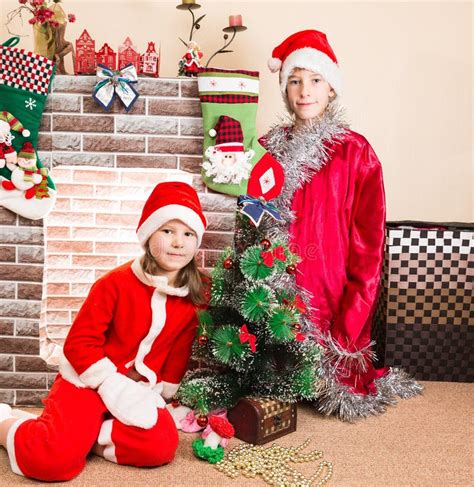 brother and sister dressed costume santa claus by fireplace christmas stock image image of