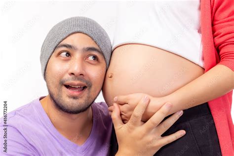 Handsome Asian Man Listening To His Beautiful Pregnant Wifes Tummy And Get Happines With