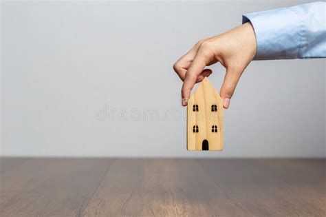 Hand Holding Wooden House On Wooden Desk Save Money And Buy House