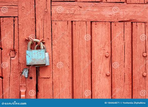 Big Iron Lock With Peeling Paint On The Old Red Wooden Door Stock Image