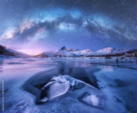 Milky Way Above Frozen Sea Coast And Snow Covered Mountains In Winter