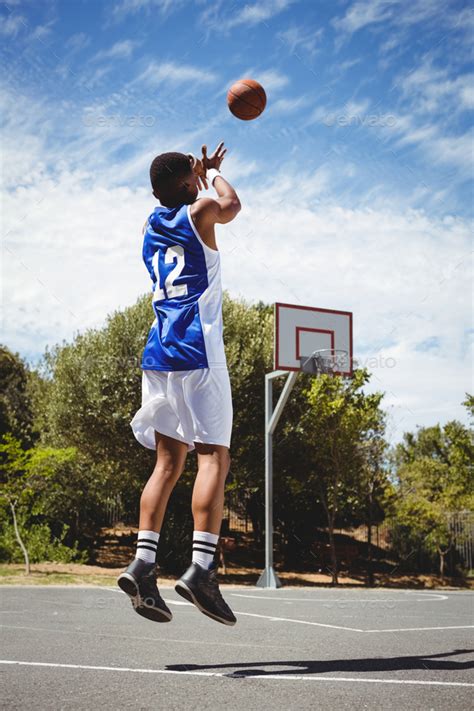 Teenage Basketball Player Scoring While Practicing In Court Stock Photo