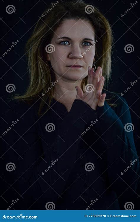 portrait of a beautiful elegant blonde woman with fingers intertwined as if in prayer stock