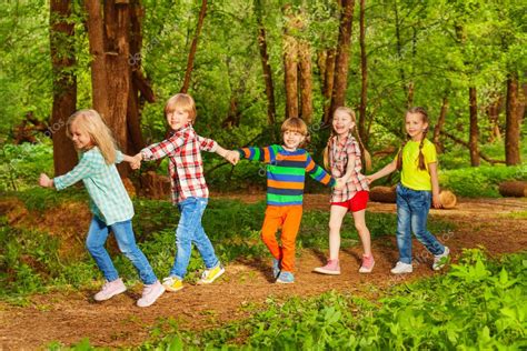 Kids Walking In Forest Holding Hands Stock Photo By ©serrnovik 130010356