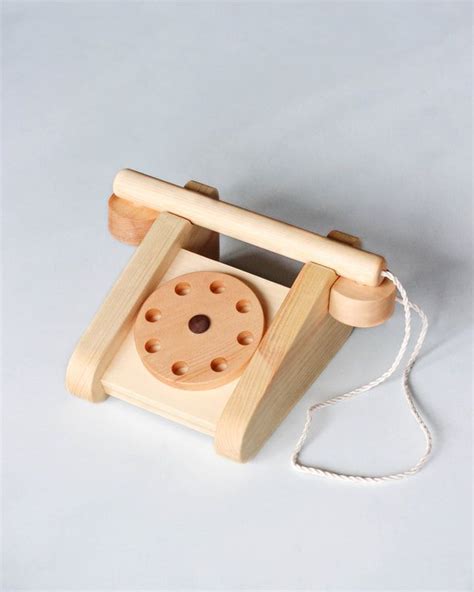 A Wooden Toy Phone With A Cord Attached To It