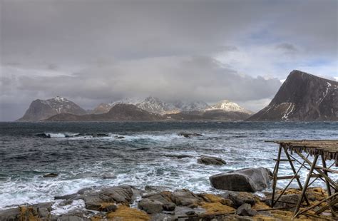 Rocky Seashore In Front Of Gray Mountains And Clouds During Daytime Hd