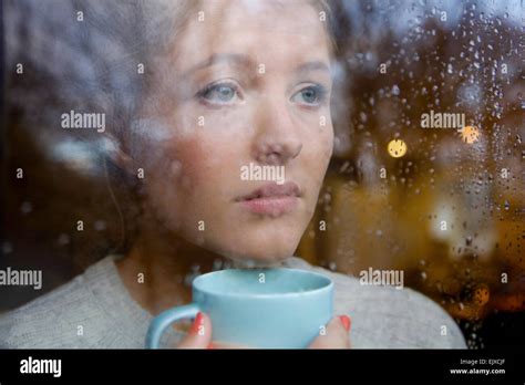 Woman Holding Drinking Cup Behind Rainy Window Stock Photo Alamy