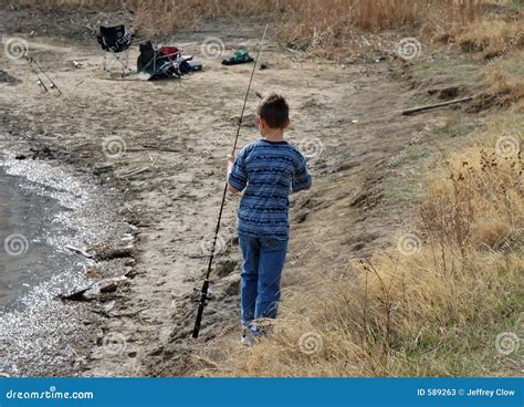 Boy With A Fishing Pole On The Shoreline Stock Photos Image 589263