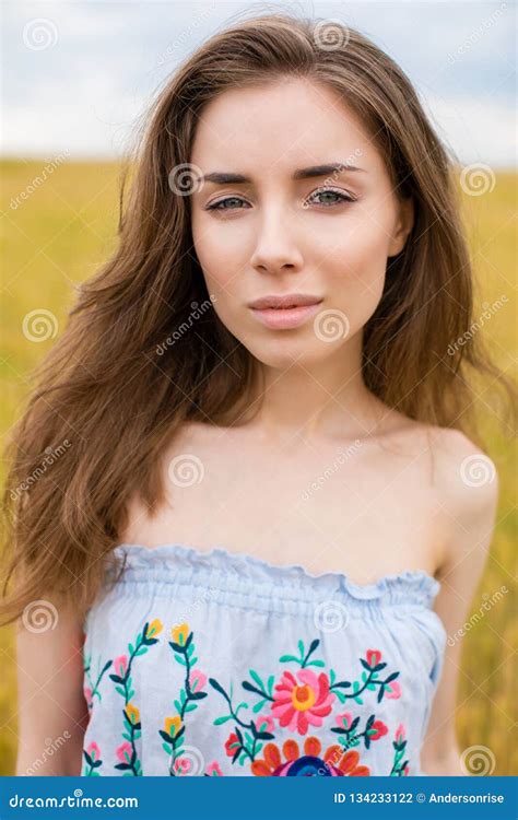 Portrait Of A Young Girl On A Background Of Golden Wheat Field Stock