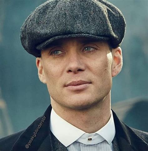 A Man In A Suit And Hat Looking At The Camera With An Intense Look On His Face