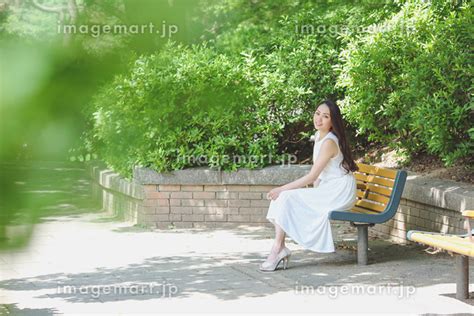 ベンチに座る女性の写真素材 129296464 イメージマート