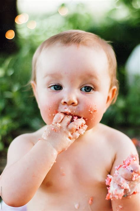 Baby Eating A Pink Cake With Her Bare Hands By Stocksy Contributor