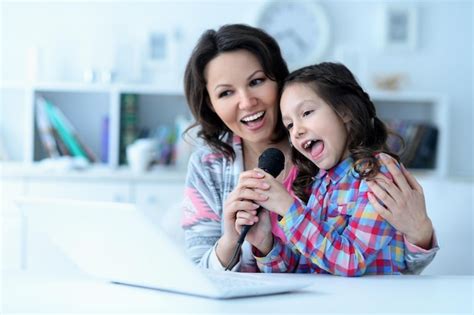 Madre E Hija Usando Una Laptop Cantando Juntas Foto Premium