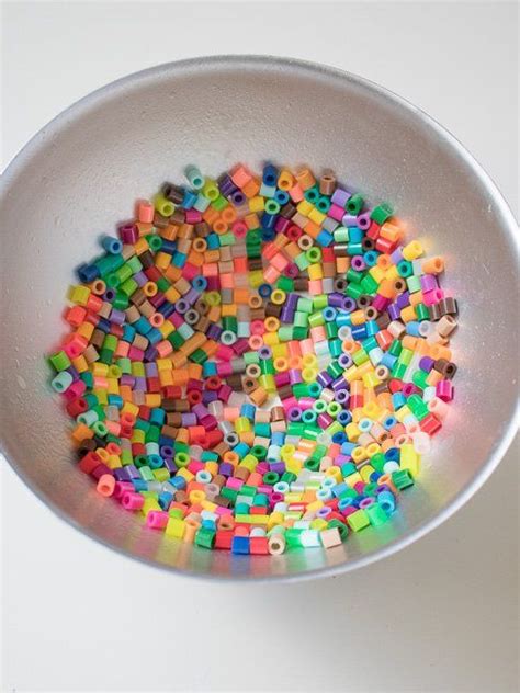 A White Bowl Filled With Lots Of Colorful Beads