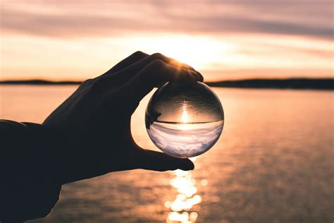 Photo Displays Person Holding Ball With Reflection Of Horizon · Free