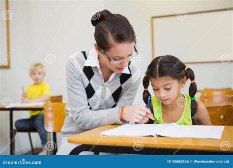 Pretty Teacher Helping Pupil In Classroom Stock Photo Image Of Early