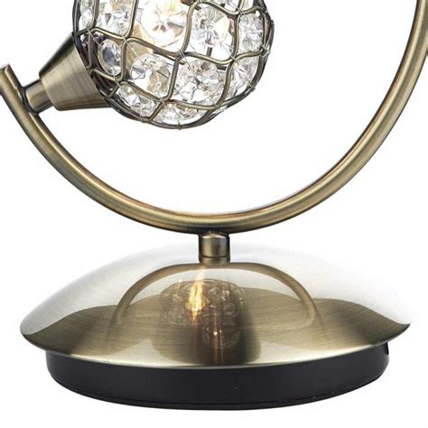Founded atop ball feet, this metal design showcases a spherical silhouette threaded with open steel rings in a sleek finish. Beaded Ball Table Lamp - Antique Brass - Lightbox