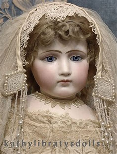An Old Doll Wearing A Wedding Dress And Veil With Pearls On Its Head