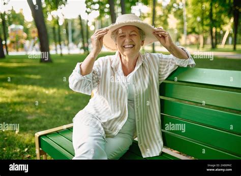 Granny In Hat Sitting On The Bench In Summer Park Stock Photo Alamy